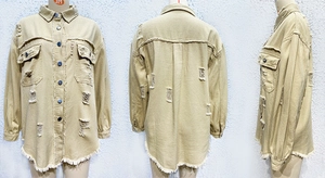 Detail view of khaki distressed denim jacket with frayed edges and ripped texture