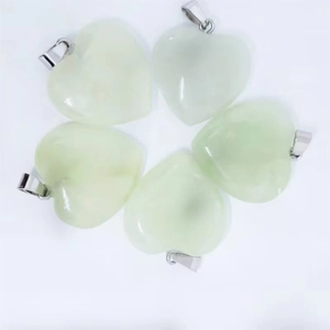 Detalle macro de cinco colgantes de cristal en forma de corazón verde claro con cierres