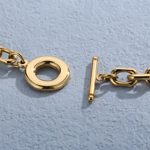 Macro detail of high-shine gold stainless steel OT toggle clasp on a heart necklace