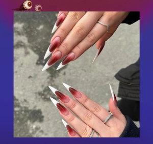 Detail of long stiletto press-on nails with red gradient and white French tips