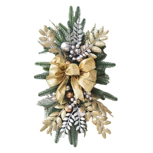 Golden and silver Christmas swag with pine needles, ornaments and a large glitter bow