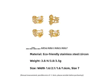 Detail of four gold stainless steel rings with starfish, shell, and pearl ocean designs