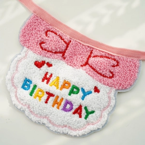 Close-up of pink pet birthday bib with Happy Birthday embroidery and soft plush texture