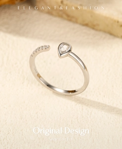 Macro detail of S925 sterling silver ring with drop-shaped zircon on beige texture