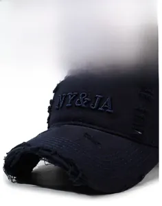 Gros plan détaillé sur casquette vintage bleu marine avec broderie NY&JA et usures
