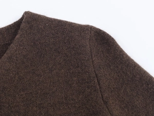 Detailed close-up of dark brown knit texture and shoulder seam on a warm winter coat