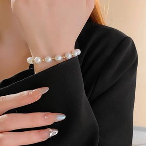 Detail of French style pearl bracelet with gold metal beads on a woman wrist