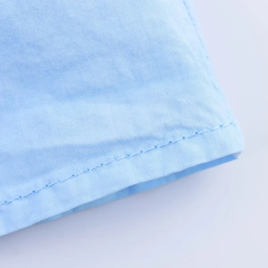 Detaillierte Nahaufnahme des hellblauen Stoffes eines Faltenkleides mit feinen Nähten