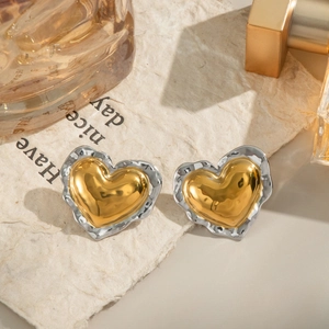 Detail of two-tone heart stud earrings featuring a gold center and hammered silver edge