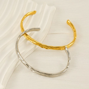 Detail shot of hammered texture open cuff bracelets in gold and silver finish