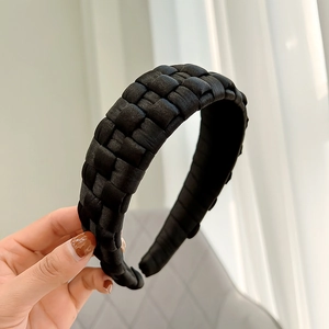 Close-up of a handmade black woven wide headband with textured satin fabric detail
