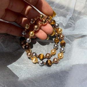Détail de perles en oeil de tigre et perles colorées avec un fermoir magnétique doré