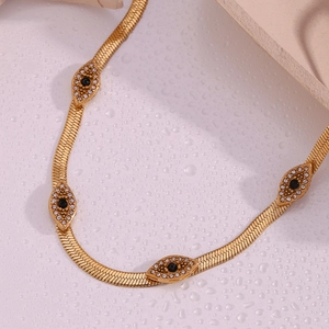 Detail of 18K gold-plated snake chain with diamond-encrusted evil eye charms