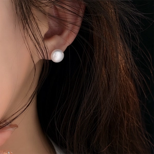 Close-up of a natural freshwater pearl stud earring worn on a model ear lobe