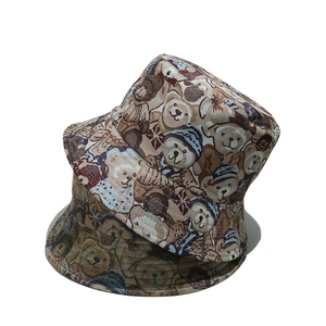 Detail of knitted bucket hats with vintage cartoon bear patterns in brown and beige colors