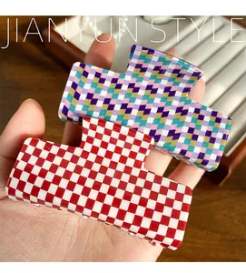 Close-up of checkerboard square hair claws in red-white and multicolored patterns