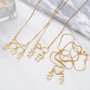Detail of gold heart necklace with boy and girl pendants featuring cubic zirconia inlays