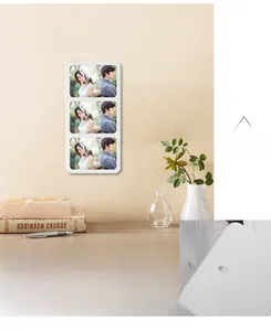 Close-up detail of wall-mounting hooks on a white minimalist triple photo frame