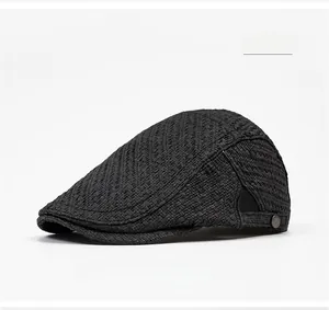 Detail of black woven ivy cap with breathable mesh texture and metal logo plaque