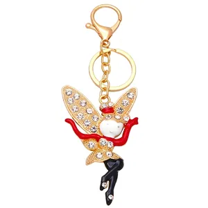 Golden fairy keychain with snowflake wings and white rhinestones on white background