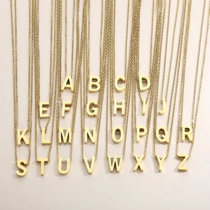 Detailed display of 26 gold stainless steel alphabet pendant necklaces arranged neatly