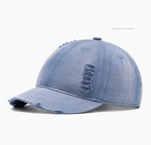Close-up of distressed blue denim baseball cap with vintage worn-out hole details