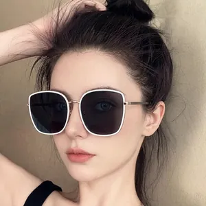 Chic oversized square sunglasses with white frames and gold bridge shown on a female model