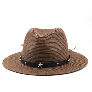 Detail of western straw hat featuring a black leather band with silver star metal studs