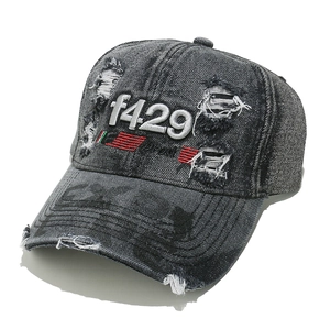 Detailed macro view of distressed denim baseball cap with 3D f429 embroidery and frayed holes