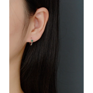 Close-up of S925 sterling silver hoop earring with green gemstone on model's ear