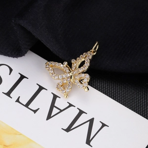 Close-up of a delicate gold butterfly pendant with sparkling cubic zirconia on wings