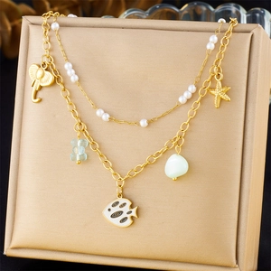 Detail of a layered ocean necklace featuring starfish, pearls, and a blue bear charm