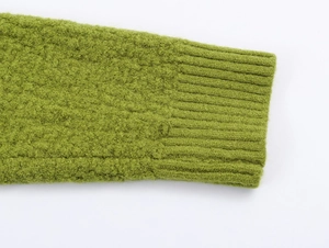 Detailed macro view of the moss green ribbed cuffs on this thick knitted cardigan sweater