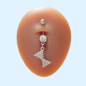 Vue détaillée du piercing de nombril argenté avec pendentif papillon en cristal