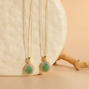 Detail view of pear and oval emerald zircon pendants with 14K gold plated chain necklace