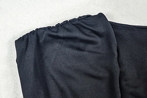 Detailed view of sophisticated ruching and V-neckline on this black sleeveless dress