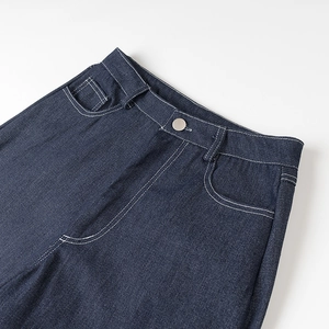 Gros plan détaillé de la taille d'un jean en denim bleu foncé avec coutures blanches