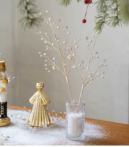 Detailed view of golden Christmas branch with white pearls and diamonds in a snowy vase