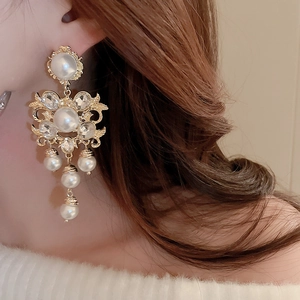 Detailed view of vintage gold hollow flower earrings with pearls and crystal tassels