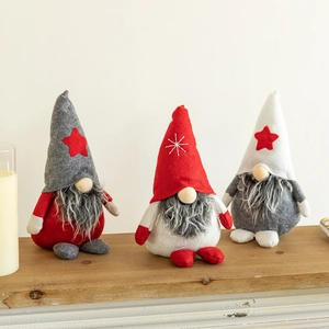 Set of 3 plush Christmas gnomes in grey, red and white colors on wooden tabletop