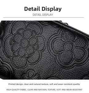 Détail du sac en cuir noir avec des motifs floraux de camélia embossés élégants