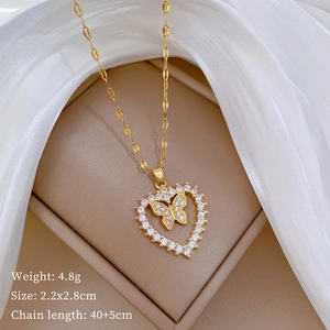 Macro detail of gold butterfly heart necklace with size and weight info on soft fabric