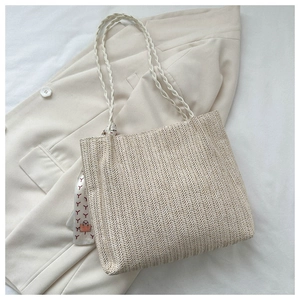 Detail of beige woven tote bag texture with decorative printed scarf on handles
