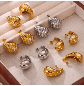 Dettaglio degli orecchini a goccia in oro e argento con strass scintillanti incastonati
