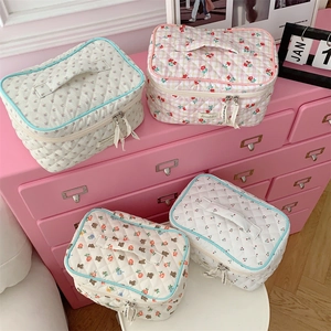 Detailed set of four quilted floral and patterned makeup bags with ribbon zip pulls