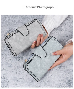 Close-up of matte long wallets in light grey and blue with gold zippers and buckles