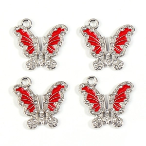 Macro detail of red butterfly alloy charms with sparkling rhinestones for DIY jewelry
