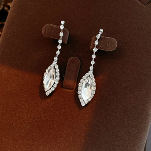 Detail of silver drop earrings with clear rhinestones and marquise cut crystals on velvet