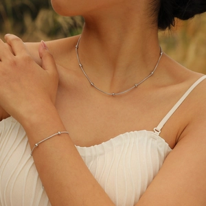 Minimalist stainless steel bead necklace and bracelet set shown on female model