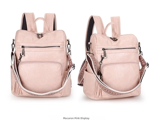 Detail view of macaron pink faux leather backpack with ethnic woven strap and tassels